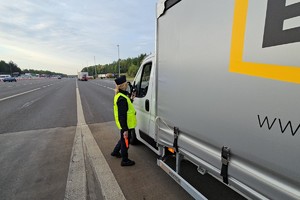 zdjęcie przedstawia policjantów w trakcie kontroli trzeźwości na autostradzie