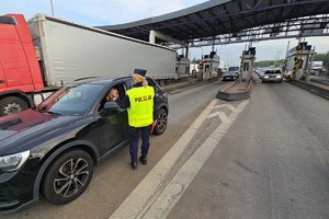 zdjęcie przedstawia policjantów w trakcie kontroli trzeźwości na autostradzie