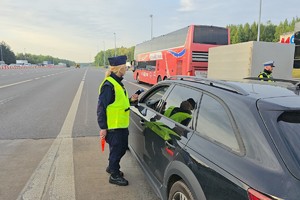 zdjęcie przedstawia policjantów w trakcie kontroli trzeźwości na autostradzie
