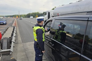 zdjęcie przedstawia policjantów w trakcie kontroli trzeźwości na autostradzie