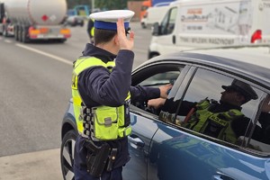 zdjęcie przedstawia policjantów w trakcie kontroli trzeźwości na autostradzie