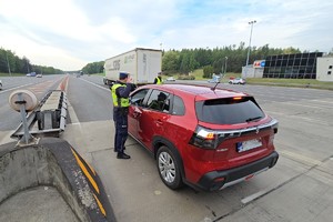 zdjęcie przedstawia policjantów w trakcie kontroli trzeźwości na autostradzie