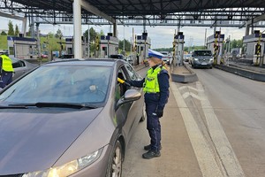 zdjęcie przedstawia policjanta w trakcie kontroli trzeźwości kierującego