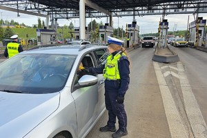 zdjęcie przedstawia policjanta w trakcie kontroli trzeźwości kierującego