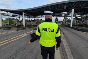 zdjęcie przedstawia policjanta w trakcie kontroli trzeźwości kierującego