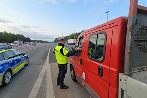 zdjęcie przedstawia policjanta w trakcie kontroli trzeźwości kierującego