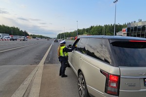 zdjęcie przedstawia policjanta w trakcie kontroli trzeźwości kierującego