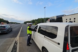 zdjęcie przedstawia policjanta w trakcie kontroli trzeźwości kierującego