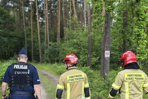 zdjęcie przedstawia policjanta i dwóch strażaków