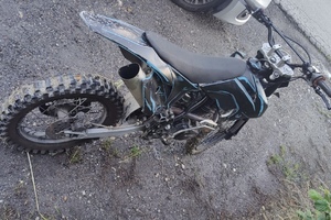zdjęcie przedstawia policjantów z zatrzymanym motocyklistą.