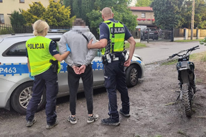 zdjęcie przedstawia policjantów z zatrzymanym motocyklistą.