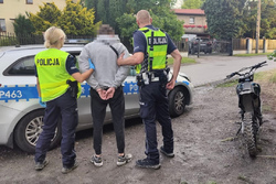 zdjęcie przedstawia policjantów z zatrzymanym motocyklistą.