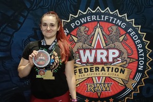 zdjęcie przedstawia policjantkę w stroju sportowym z medalami na szyi.