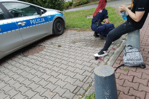 zdjęcie przedstawia policjantkę przystępującą do opatrywania nogi poszkodowanego