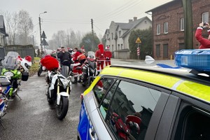 zdjęcie przedstawia policjantów zabezpieczających przejazd motocyklistów w strojach mikołajów