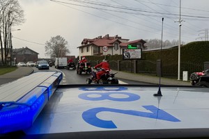 zdjęcie przedstawia policjantów zabezpieczających przejazd motocyklistów w strojach mikołajów