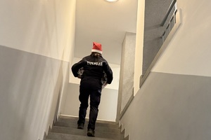 zdjęcie przedstawia policjanta niosącego paczkę