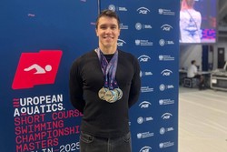 zdjęcie przedstawia mężczyznę z medalami na szyi