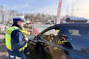 zdjęcie przedstawia policjantów w trakcie kontroli drogowej.