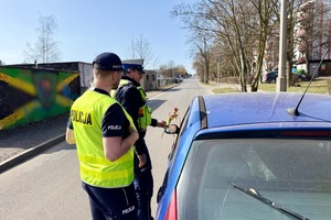 zdjęcie przedstawia policjantów w trakcie kontroli drogowej.