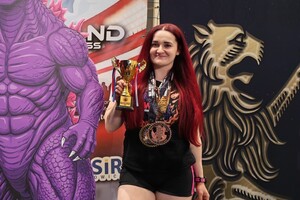 kobieta w stroju sportowym z medalami na szyi i pucharem w ręku