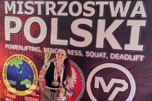 Kobieta w stroju sportowym z medalami na szyi i pucharami w rękach.