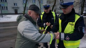 Policjanci wręczają elementy odblaskowe