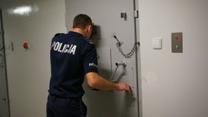 Policjant kontroluje pomieszczenie dla zatrzymanego