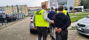 Policjanci doprowadzają dwóch zatrzymanych