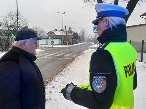 Policjantka rozmawia z pieszym który stoi przy drodze