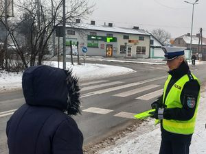 Kobieta rozmawia z policjantką, która stoi przy przejściu dla pieszych