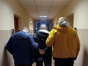 Zdjęcie osoby zatrzymanej z policjantami