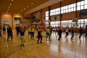 Uczestnicy zajęć sportowo-tanecznych ćwiczący na hali sportowej