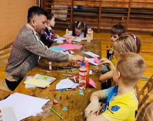 Prowadzący warsztaty z origami wraz z dziećmi