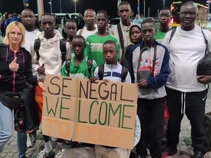 Policjantka wraz z piłkarzami z Senegalu, którzy trzymają w rękach plakat z napisem &quot;Senegal Welcome to Piekary&quot;