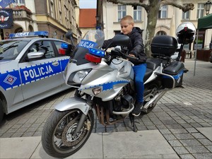 Zdjęcie kolorowe: chłopiec na policyjnym motocyklu