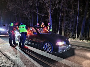 Zdjęcie przedstawia policjantów przy kontrolowanym samochodzie.