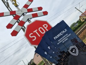 Zdjęcie przedstawia: ulotki informacyjne, z tyłu widoczny krzyż Andrzeja i znak Stop.
