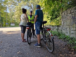 Zdjęcie przedstawia: policjanta podczas rozmowy z rowerzystami.
