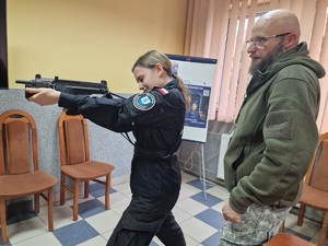 Zdjęcie przedstawia: uczennicę i instruktora podczas ćwiczeń z bronią.