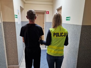 Zdjęcie przedstawia zatrzymanego mężczyznę z policjantką.