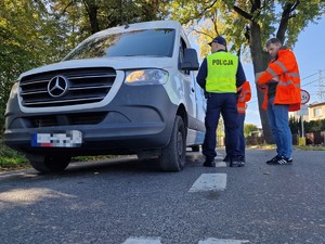 Zdjęcie przedstawia: 
Auto dostawcze oraz umundurowanego policjanta i przedstawicieli Kolei Śląskiej.