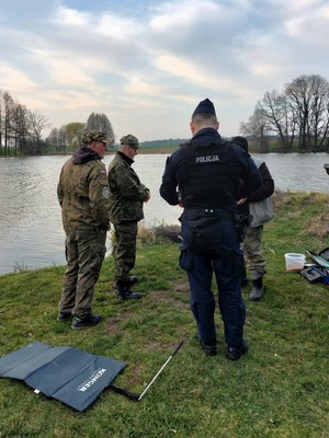 Zdjęcie przedstawia: funkcjonariuszy nadleśnictwa rozmawiających z umundurowanym policjantem