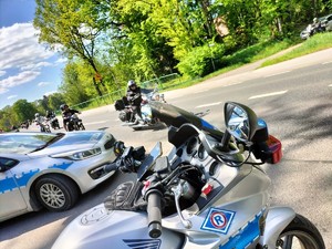 Zdjęcie przedstawia: radiowóz i motocykle policyjne.