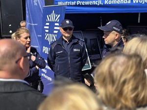 Zdjęcie przedstawia: policjantów przemawiających do grupy ludzi.
