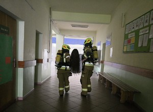 Zdjęcie przedstawia: strażaków wynoszących poszkodowaną