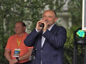 Zdjęcie przedstawia: mężczyznę mówiącego do mikrofonu