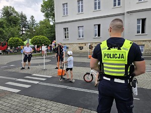 Zdjęcie przedstawia:  policjantów z dziećmi w miasteczku rowerowym