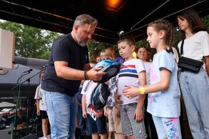 Zdjęcie przedstawia: mężczyznę wręczającego nagrody