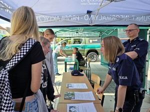 Zdjęcie przedstawia: dwie osoby umundurowane rozmawiające z młodzieżą.